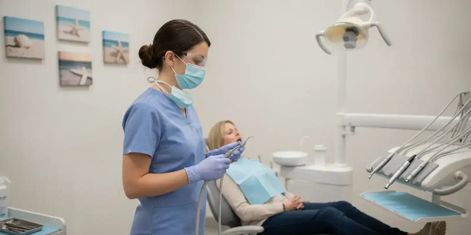 Dental hygienist preparing instruments for a routine dental cleaning in a bright treatment room